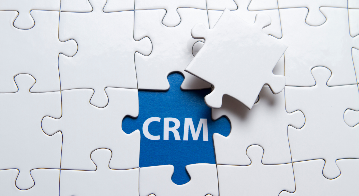 Une pièce de puzzle marquée CRM complétant un ensemble, illustrant un CRM pour agence immobilière.